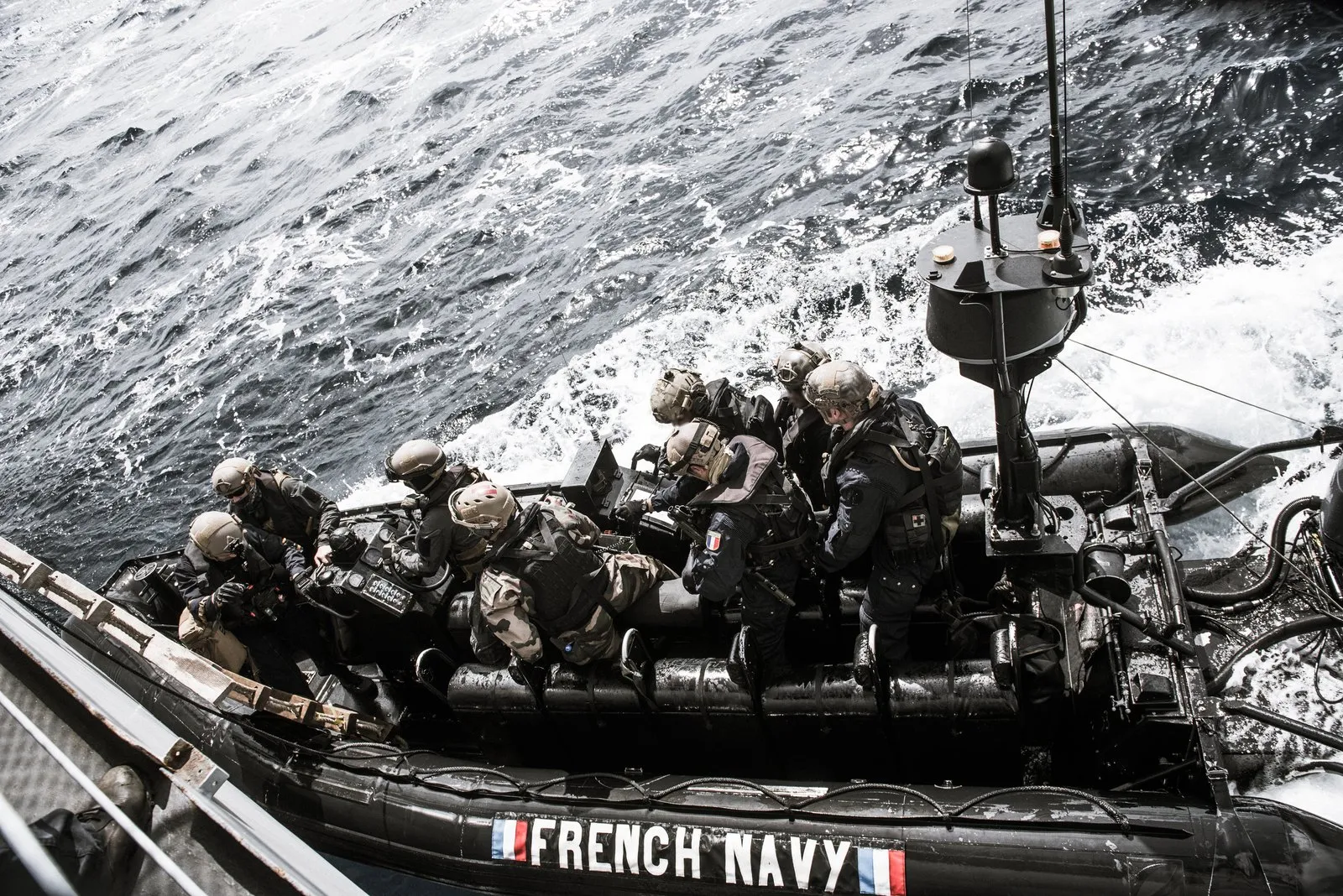 Une équipe de commandos marine, casqués et équipés, embarquée dans une embarcation semi-rigide ETRACO de la Marine nationale filant sur la mer.