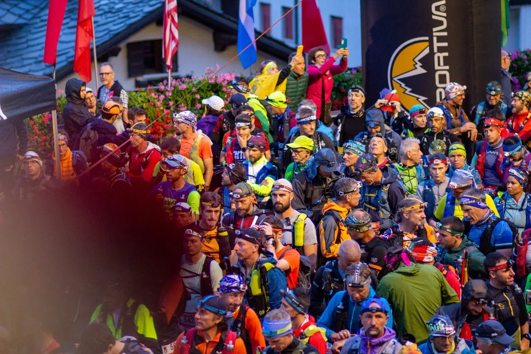 Coureuses et coureurs massés au départ du GTC 100 à Courmayeur, frontales sur la tête, sous la bannière La Sportiva.